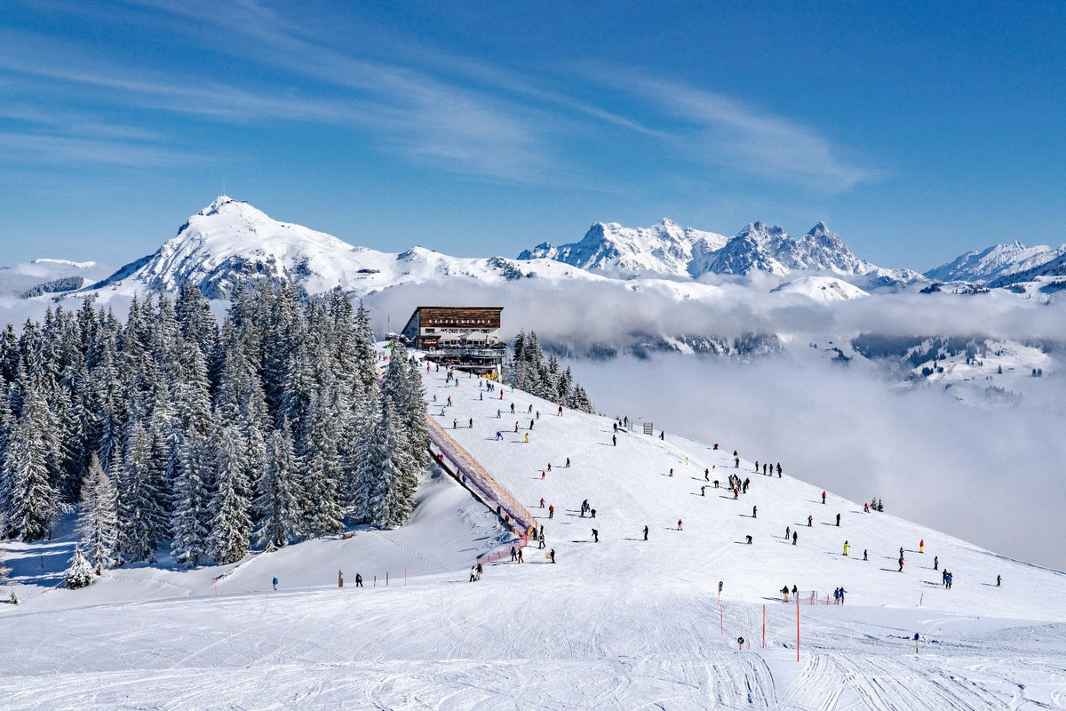 Zimná panoráma Hahnenkammu v Kitzbüheli so zjazdovkou a lyžiarmi