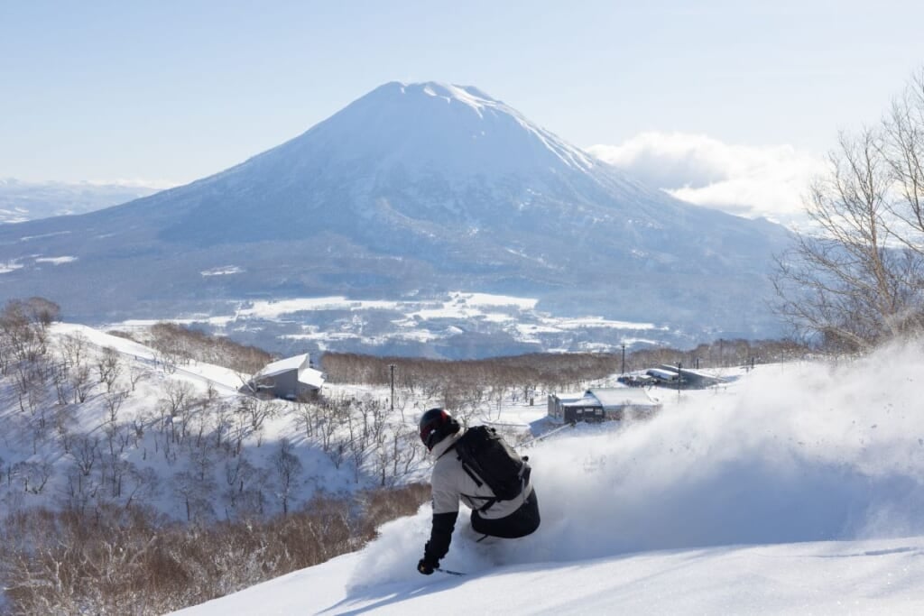Skiing through deep powder on a bluebird day at Niseko United