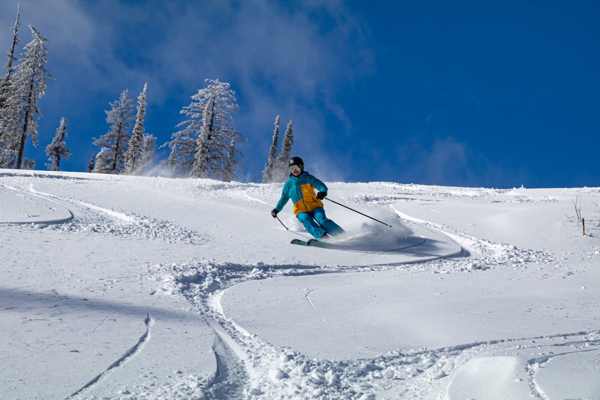 Person skiing through powder on a bluebird day
