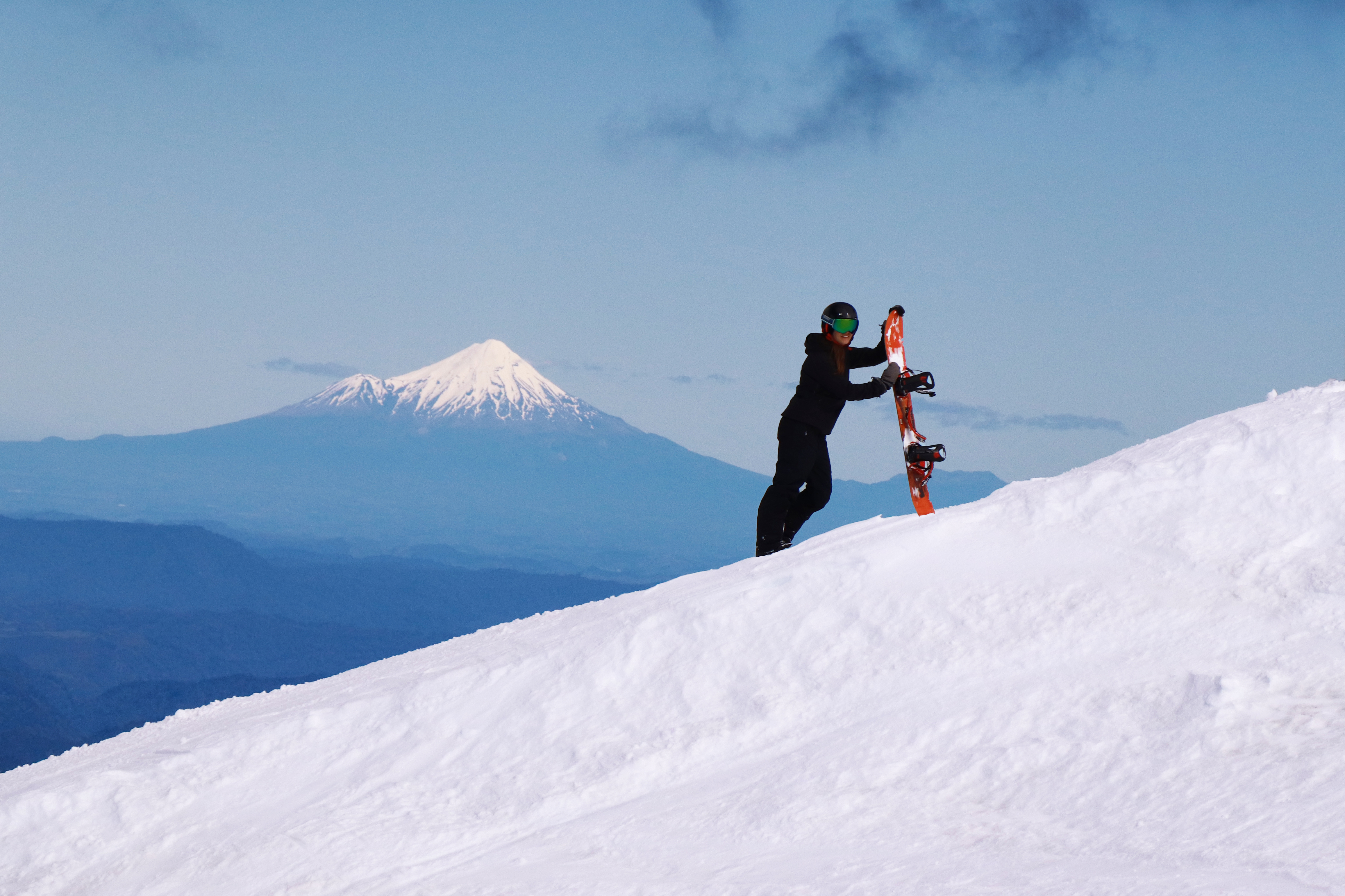 Snowboarding standing on slopes with view of Mount Taranaki from Turoa