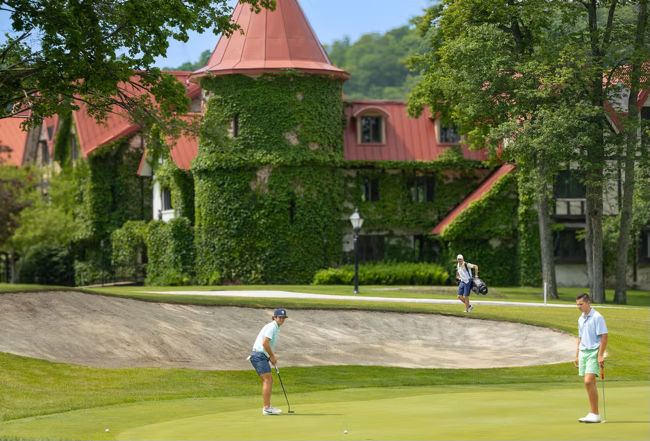 Friends on putting green next to sand bunker at golf course