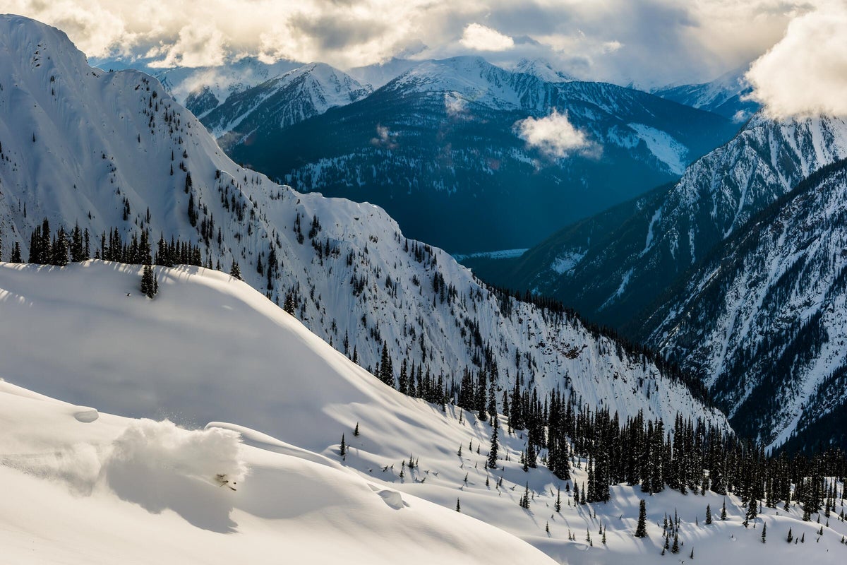 Skiing through powder on a party cloudy day in the mountains