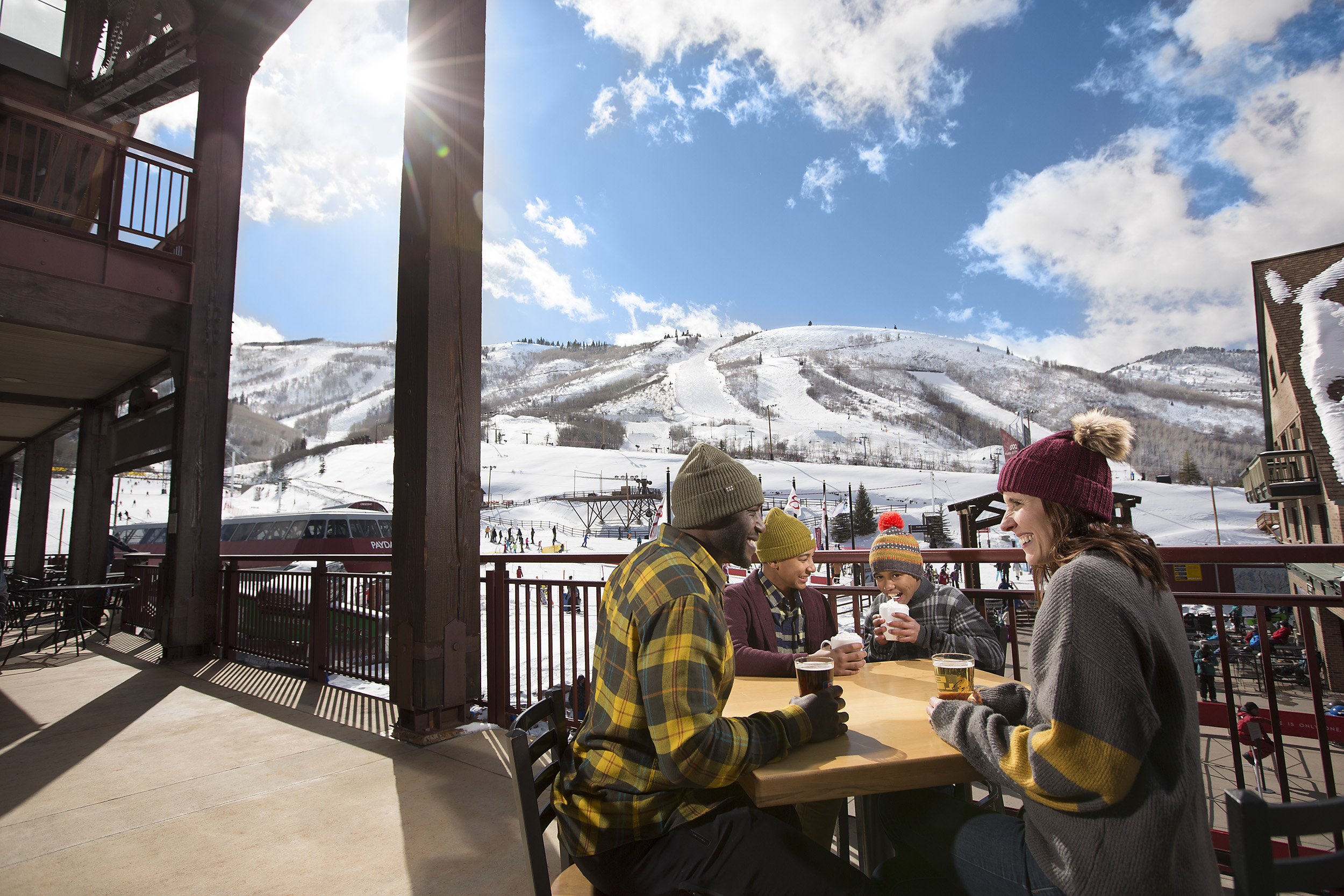 Family enjoying drinks on patio in Park City overlooking slopes