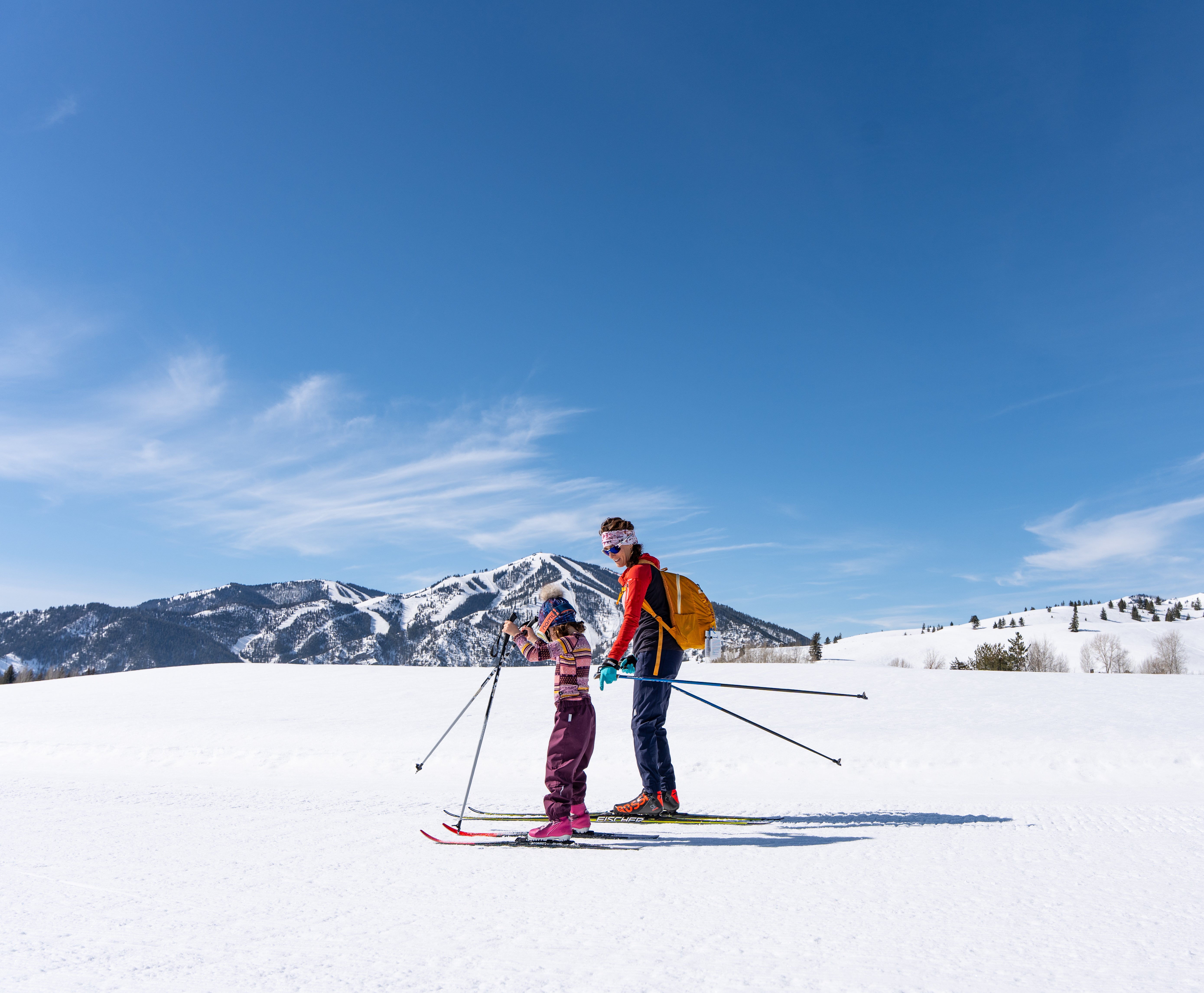 Mother and daughter skiing together on a sunny day