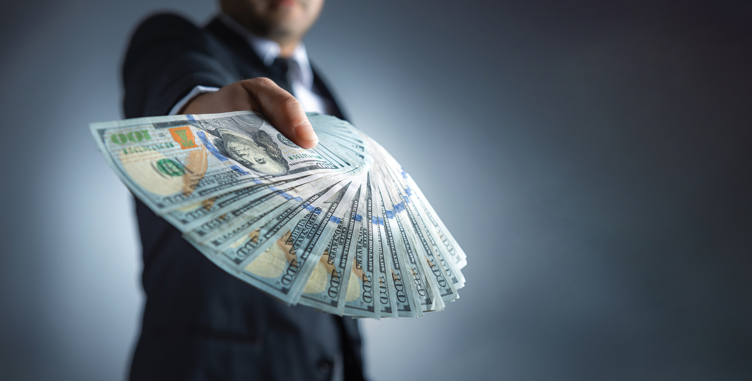 Person holding fanned out money.