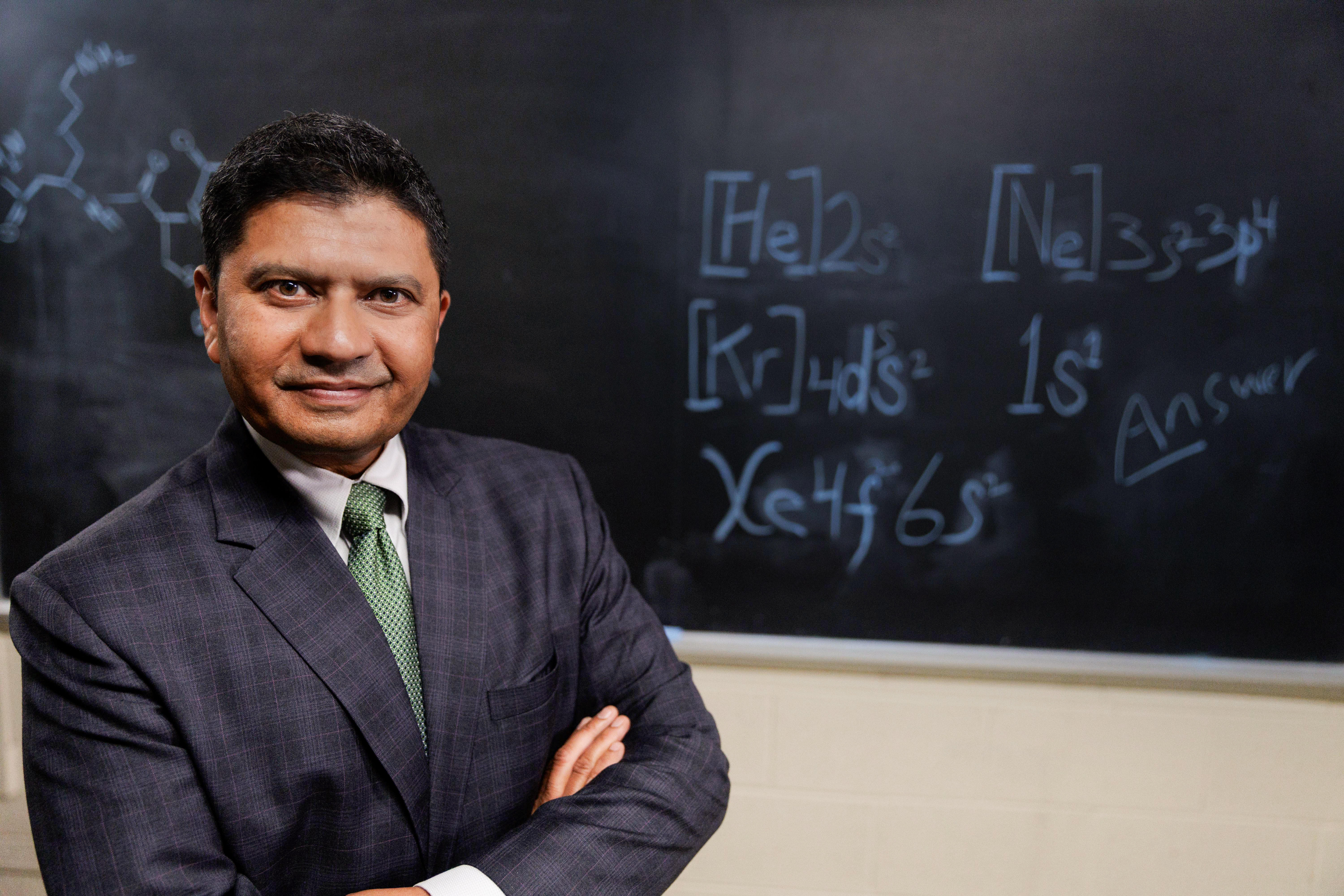Portrait of a man in front of a chalkboard