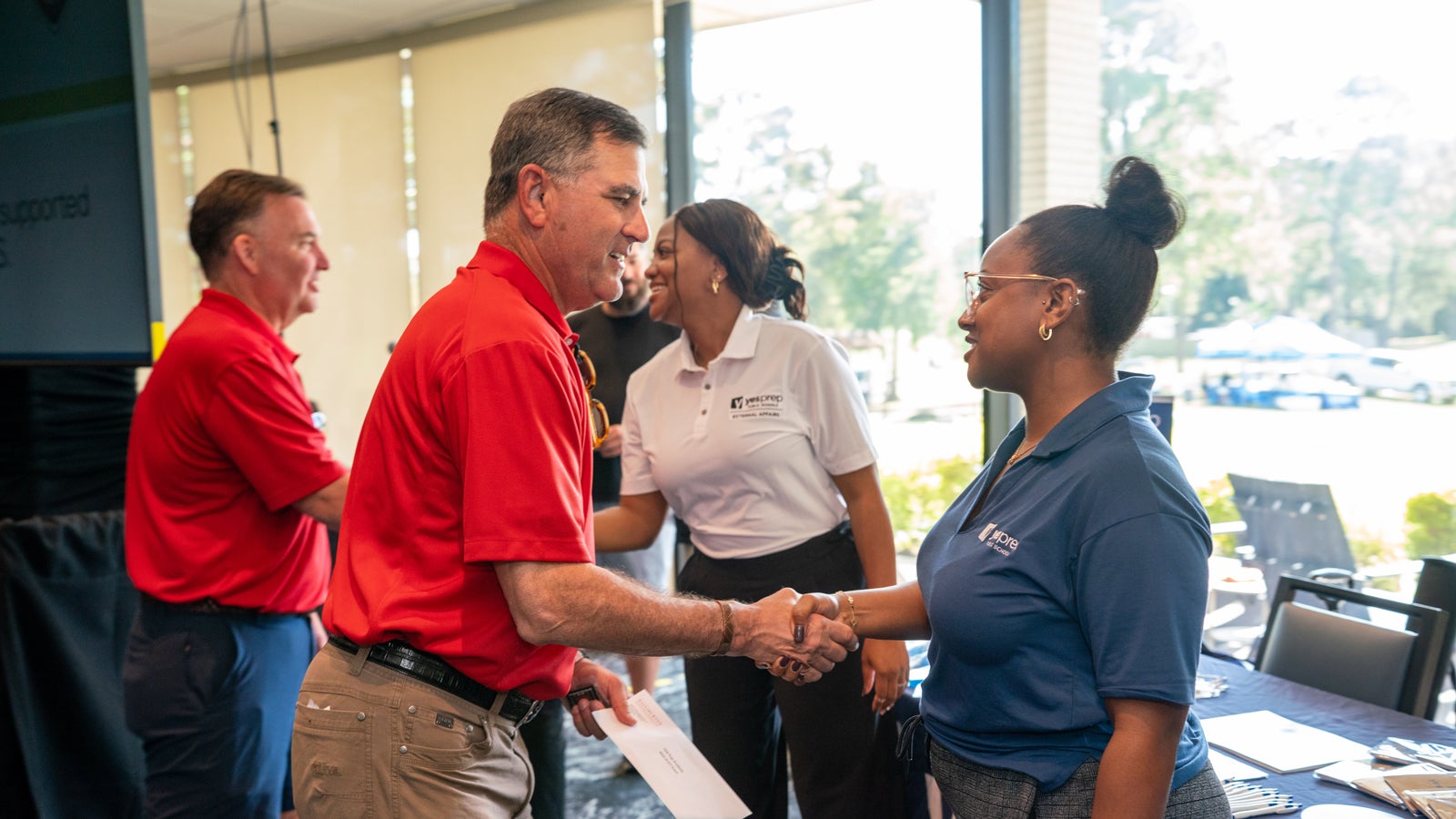 Jeff Miller shaking hands with charity representative.