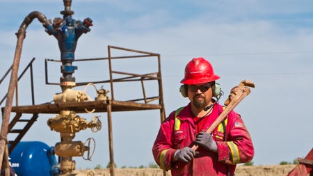 Halliburton engineer wearing red coveralls working at a rig site.