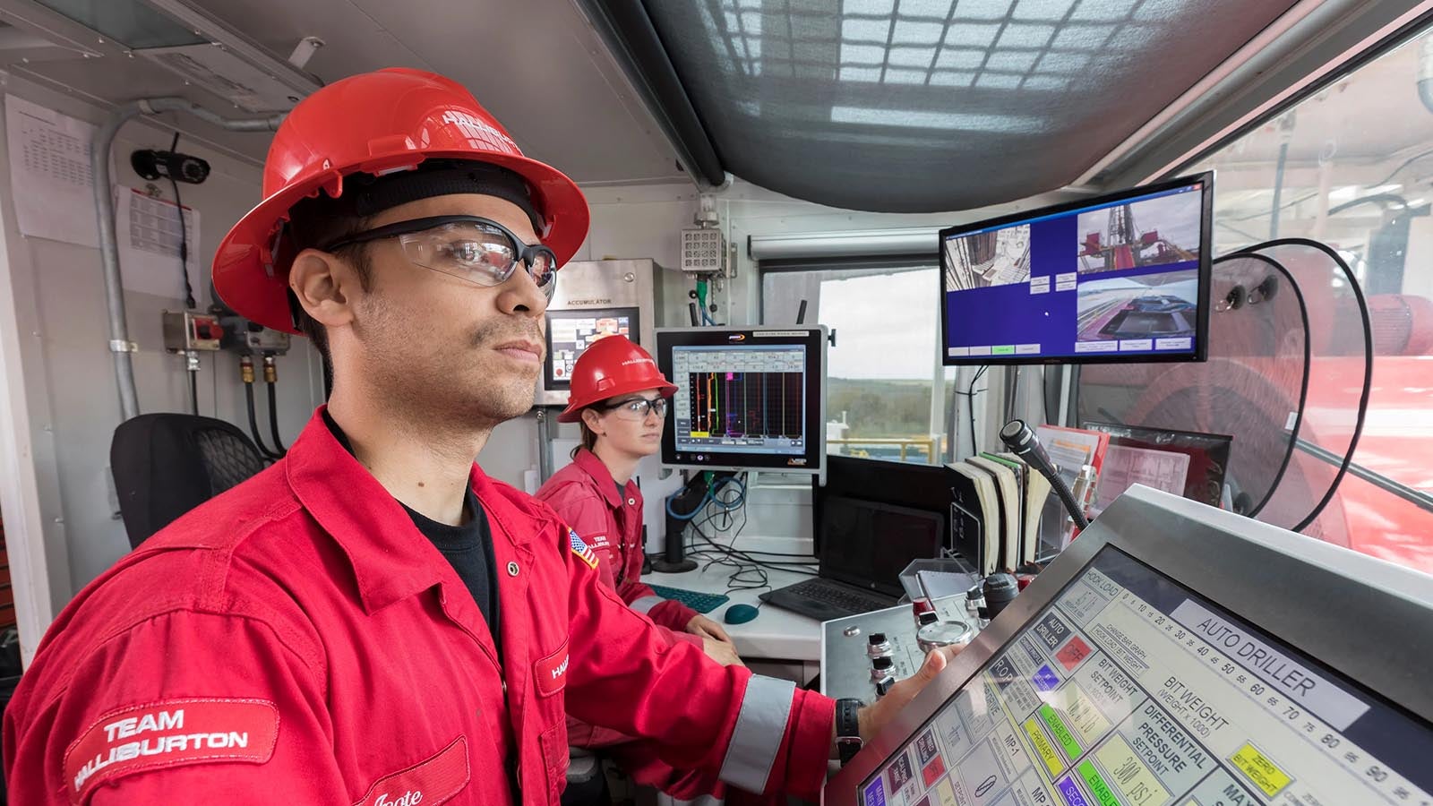 Halliburton employees monitoring rig site operations digitally