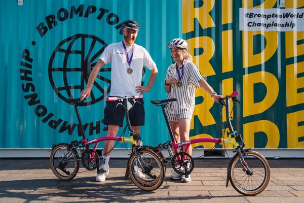 Two winners of BWC stood with Brompton bikes