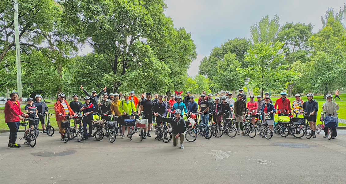 A group of Brompton riders and their bikes in the park