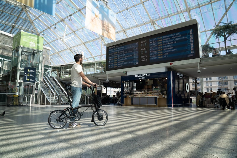 man with brompton bike in paris train station