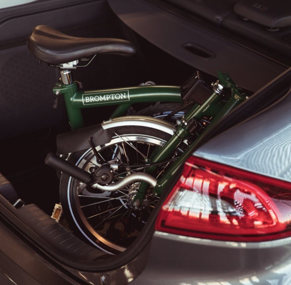 A Brompton bike folded in a car trunk