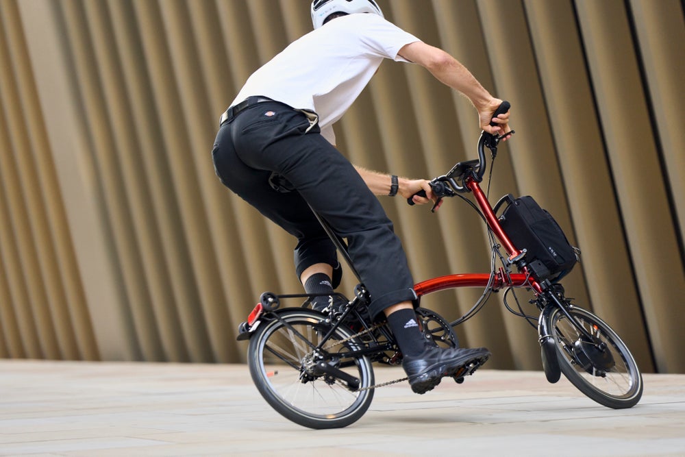 A lifestyle shot of a man riding a brompton p line electric in flame lacquer
