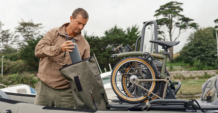 image of Bear Grylls with the Brompton collaboration bike folded