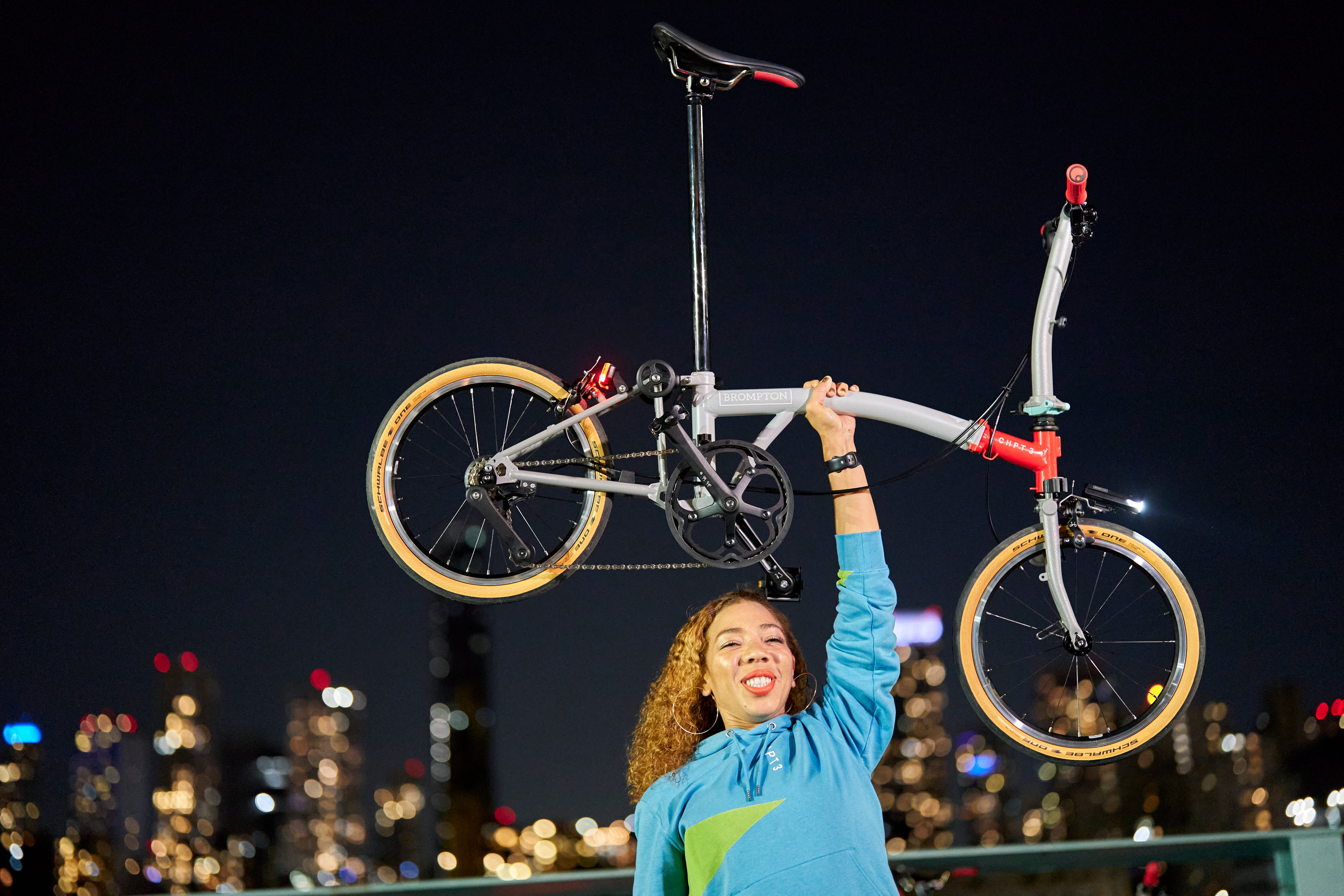 Woman holding up CHPT3 Brompton bike