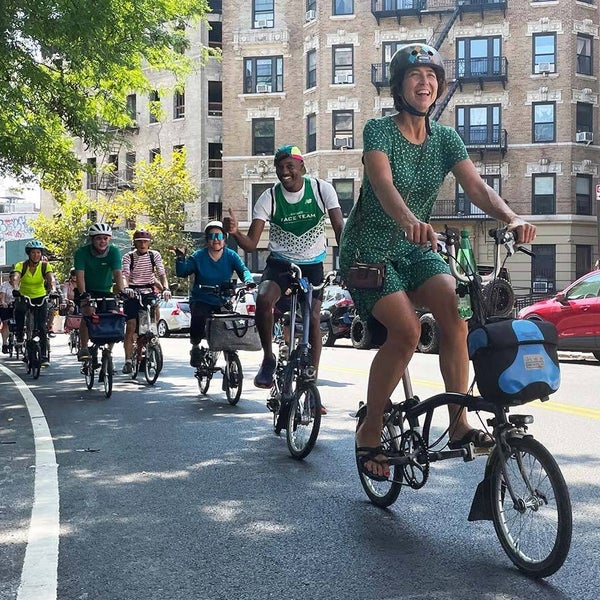 A group of happy cyclists riding through NYC on their Brompton folding bikes, part of the Brompton Meetup group