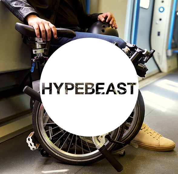 Hypebeast logo in white circle over Brompton bicycle