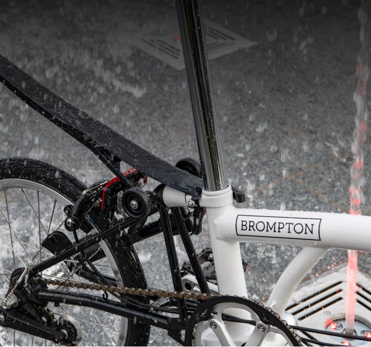 A close-up image of a Brompton A Line with fenders in the snow