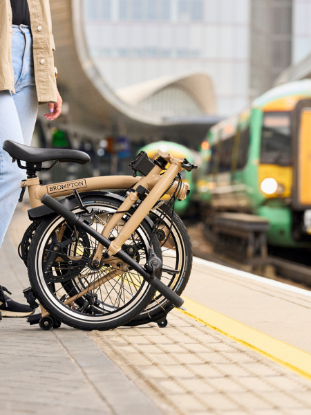 Person standing on train platform with a train sitting on the opposite platform