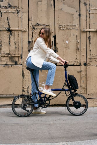 person riding brompton electric through paris