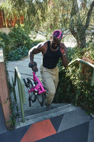 person carrying folded brompton bike upstairs