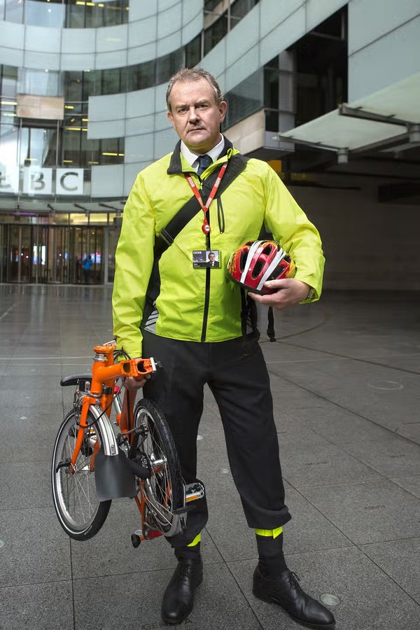 A photo of Hugh Bonneville with a folded Brompton bike