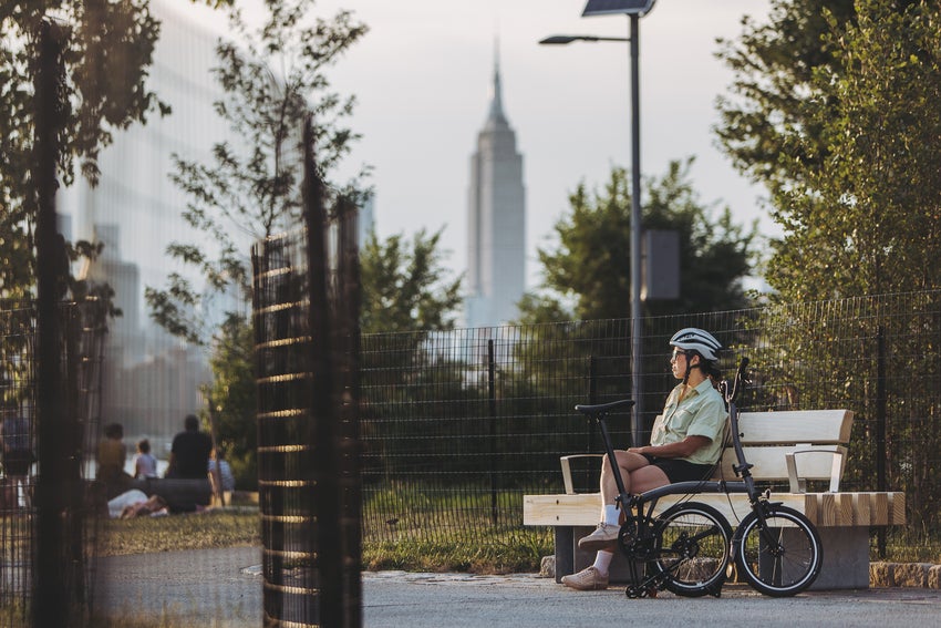 Bild von Person Radfahren Brompton Fahrrad über die Straße in New York City