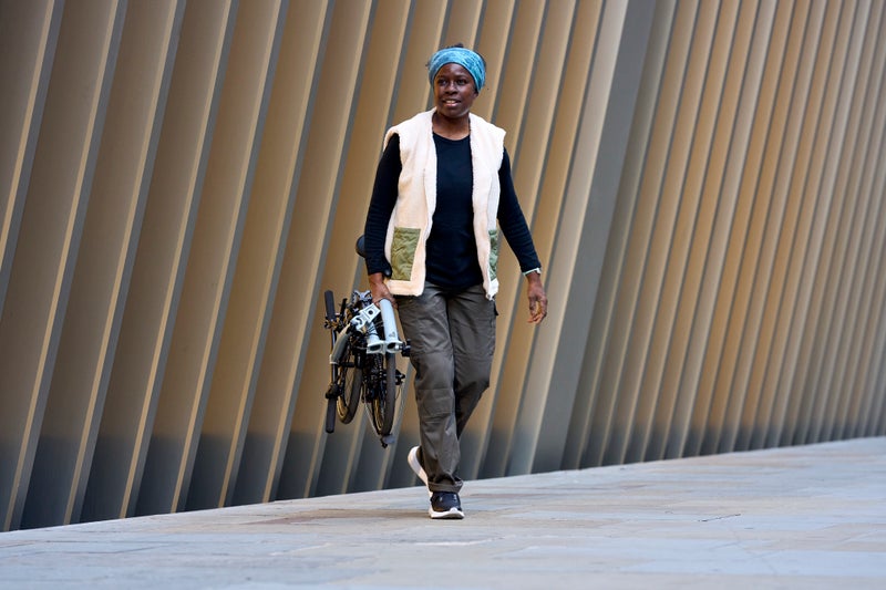 Person carrying a folded Brompton P Line bike