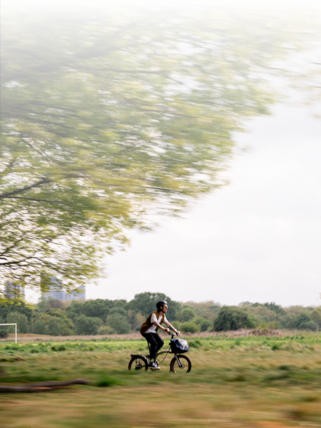 Man riding away from city through a park on G Line