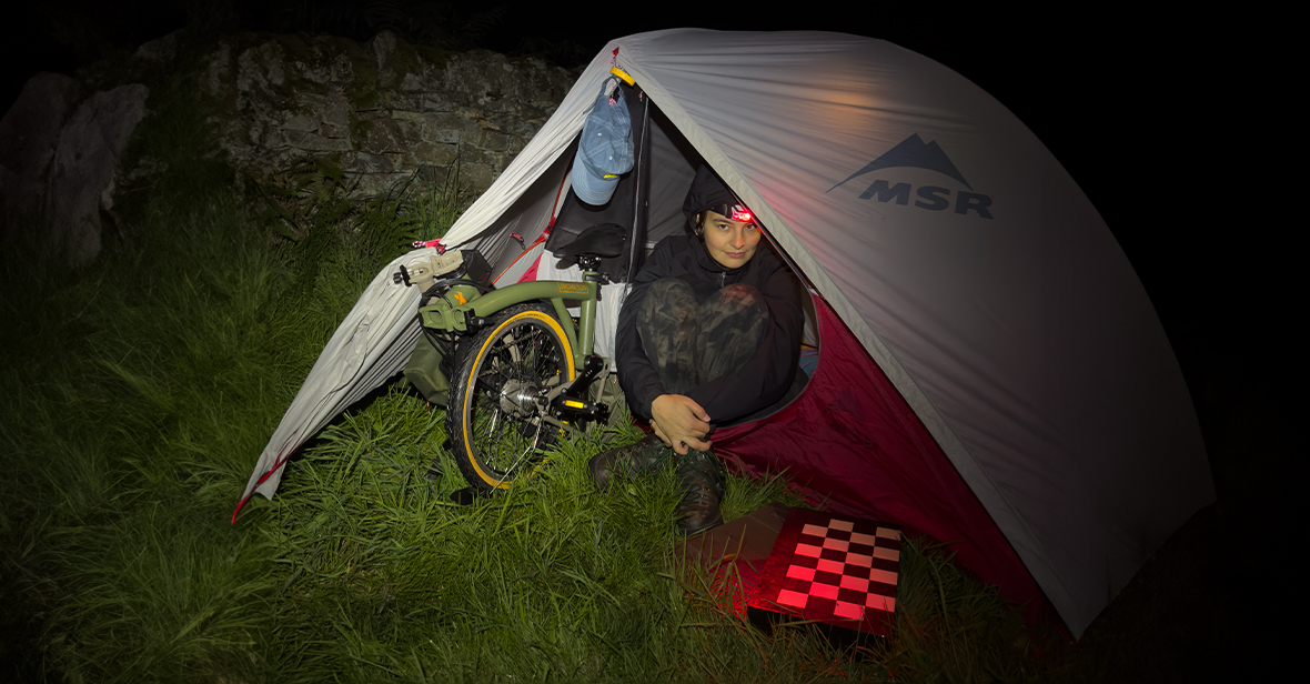Photographer Dani KM in a tent with her Brompton x Bear Grylls folding bike