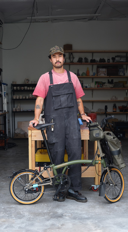 Danny Dooreck holding his Brompton x Bear Grylls collaboration bike