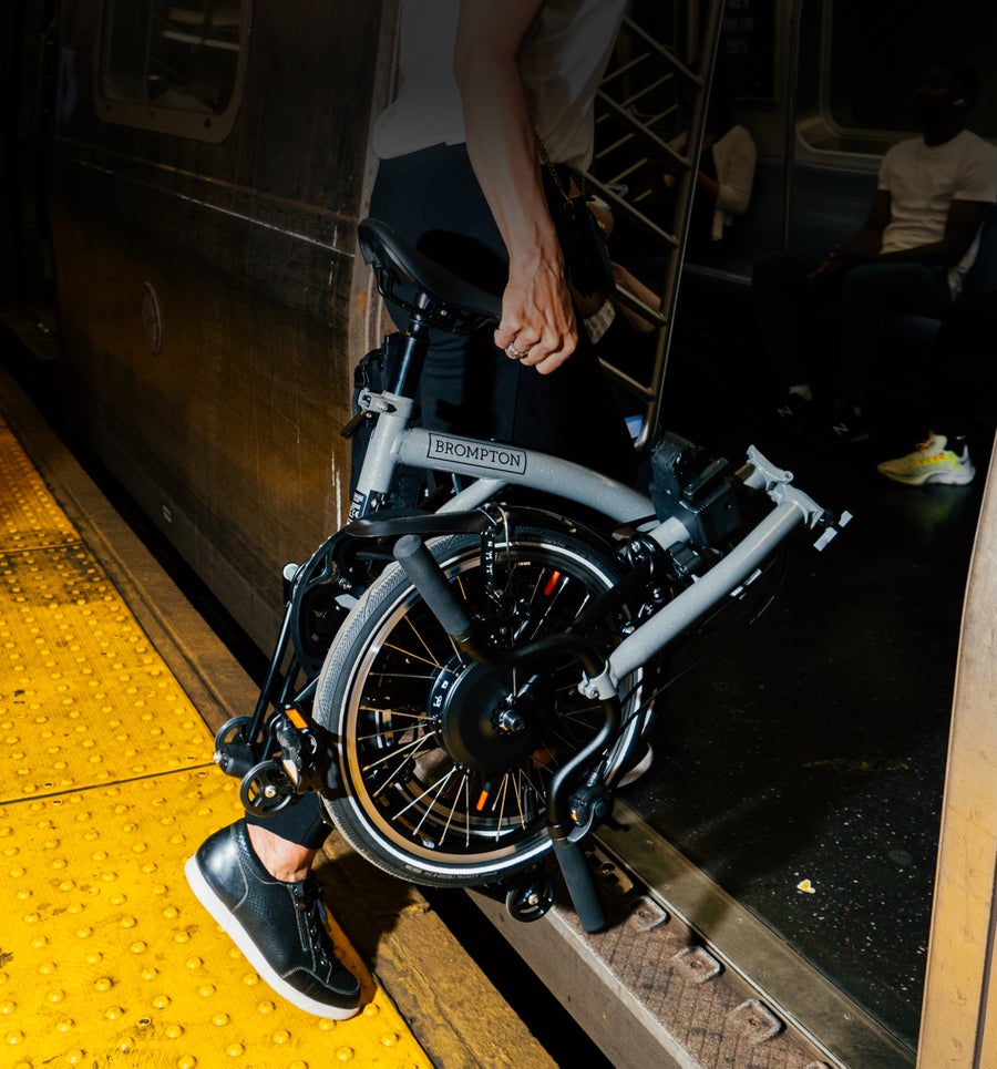 A folded Brompton P Line getting carried onto the subway of NYC