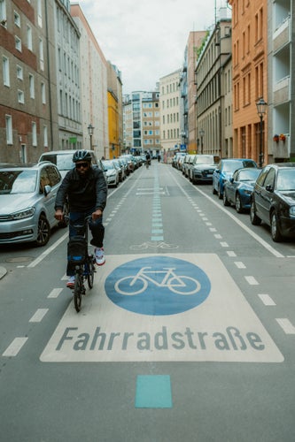 person cycling a brompton folding bike on a cycle path in berlin 