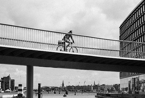 Image of person cycling over a bridge on a Brompton