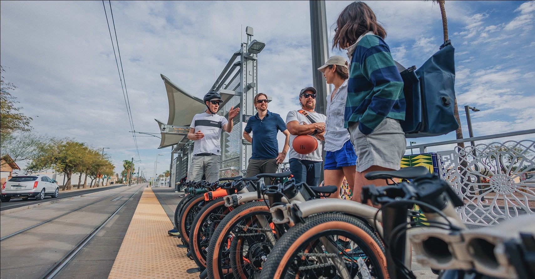 People standing on a train platform with folded Brompton bikes next to them