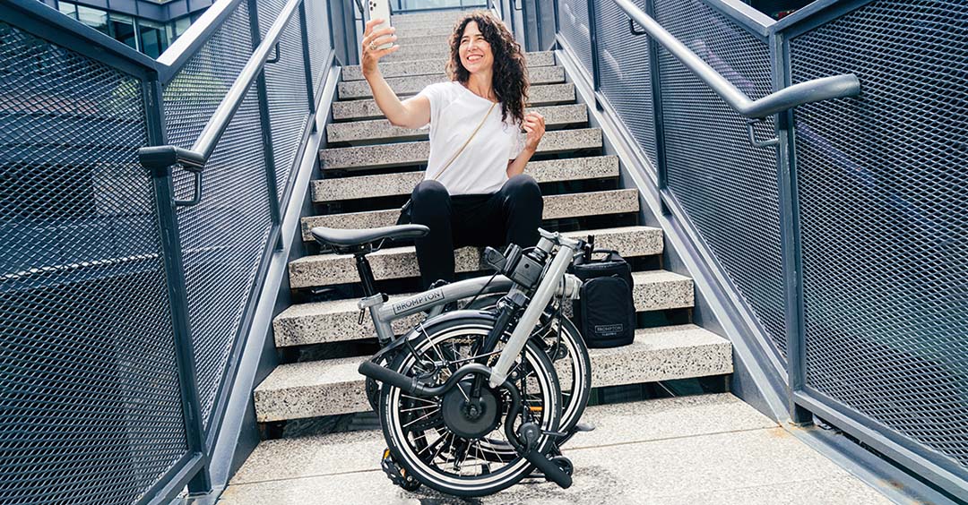 Woman sat on steps with a Brompton folded in front