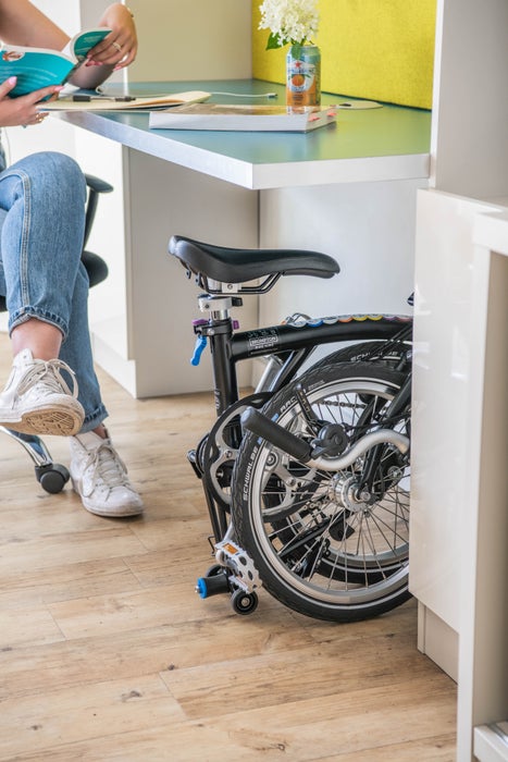 Person saß mit zusammengeklapptem Brompton-Fahrrad