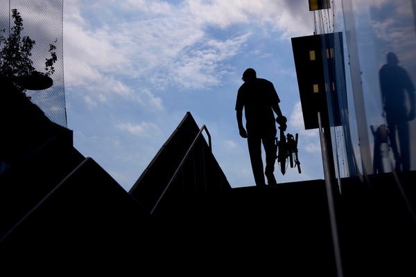 silhouette of a person carrying a brompton t line bike upstairs