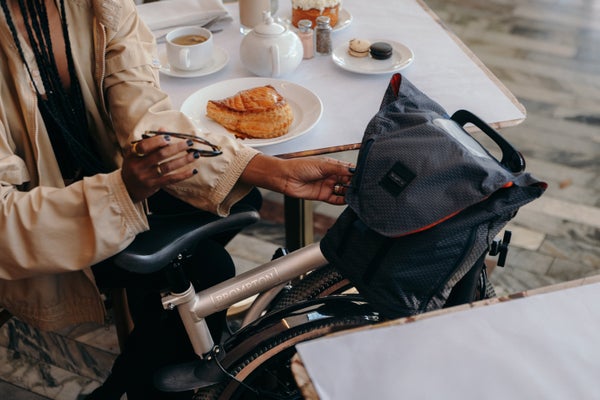 Person sat with folded Brompton Electric G Line