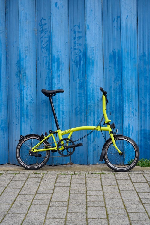 brompton c line in yuzu lime in front of blue background