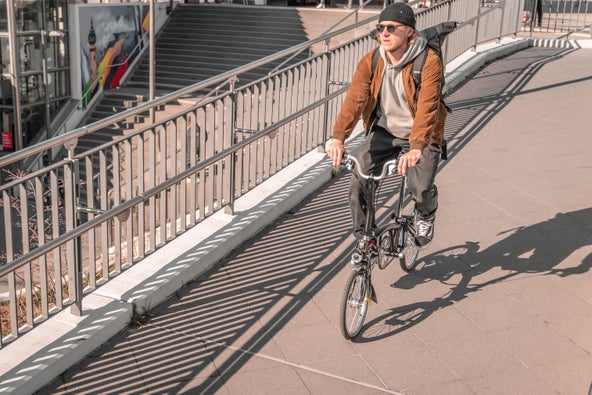 person riding brompton bike over a bridge