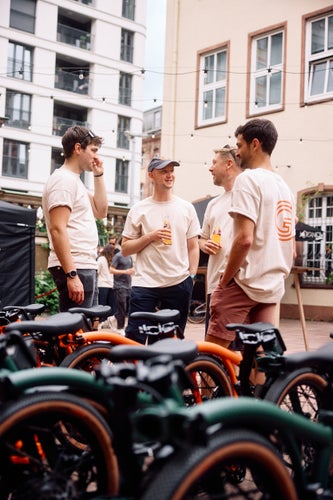 People stood talking with Brompton bikes in foreground
