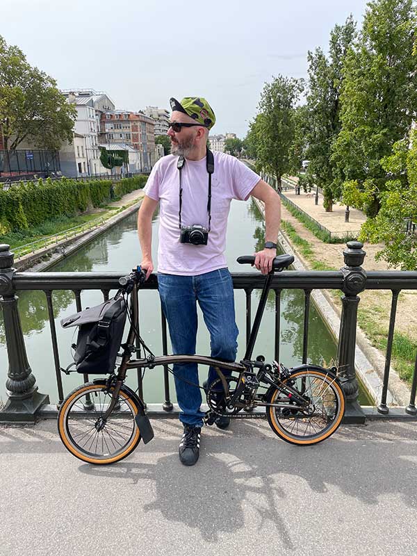 Man stood with Brompton bike on bridge