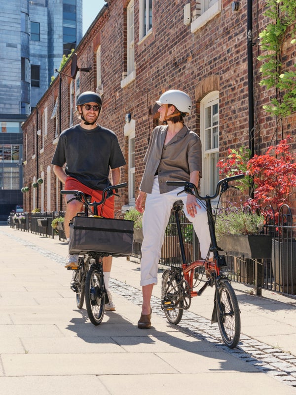 Zwei glückliche Menschen auf Brompton-Klapprädern in Manchester