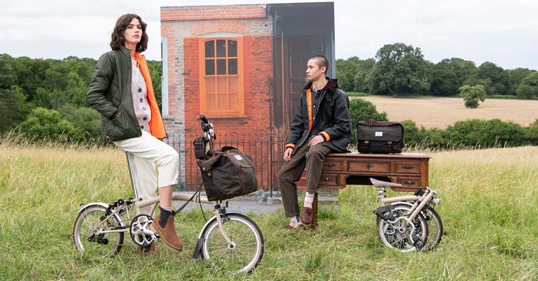 Man and woman on Brompton bikes in field