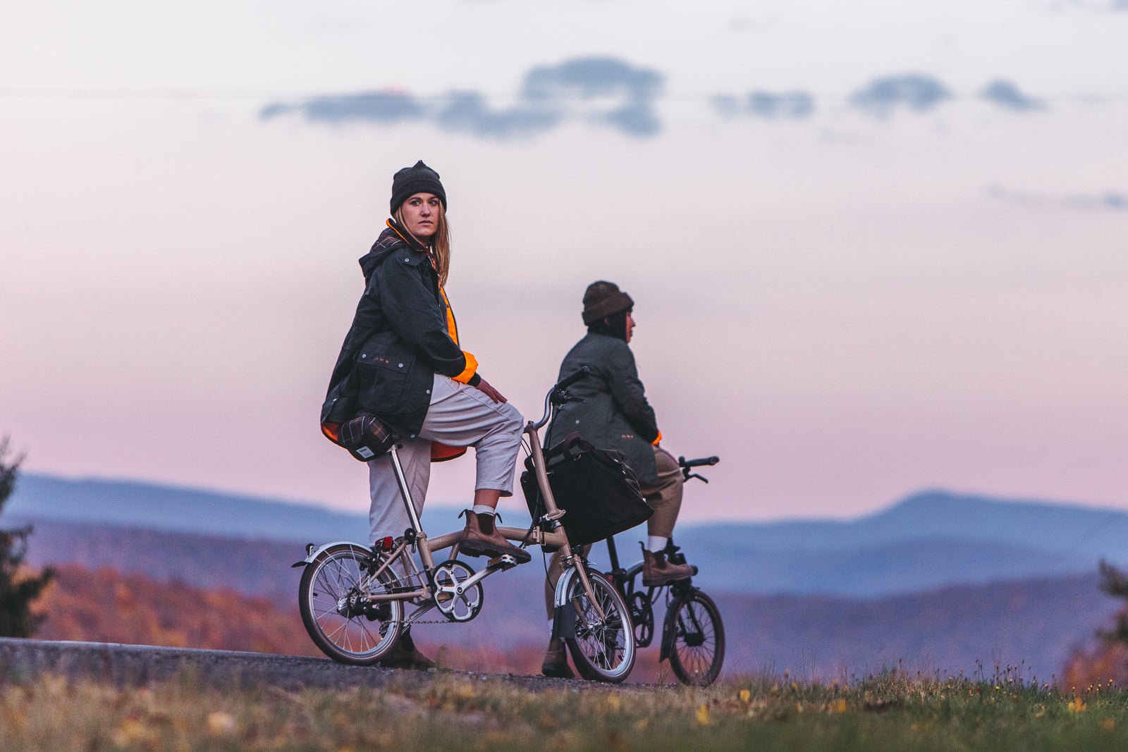 Two women on Barbour x Brompton C Lines in the sunset