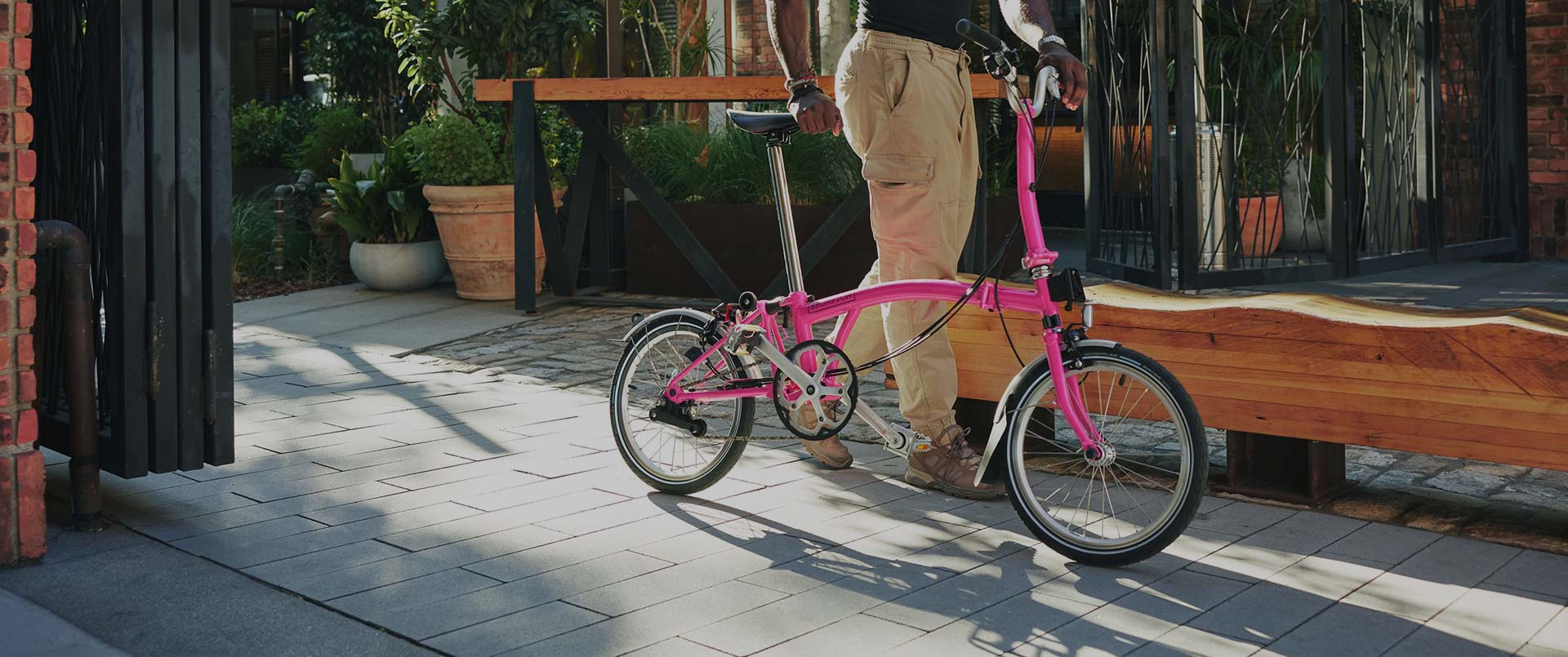 Hot Pink Archive bike being pushed along sidewalk