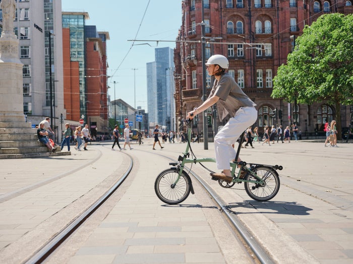 persona su una bicicletta pieghevole Brompton a Manchester