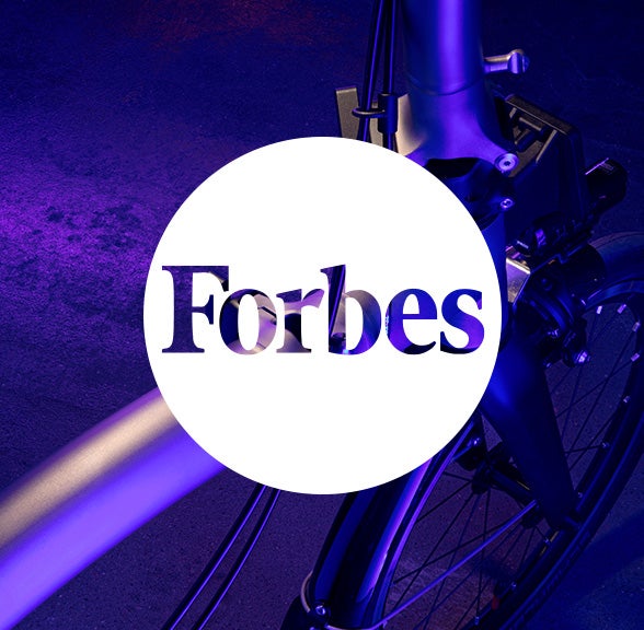 Forbes logo in white circle over Brompton bicycle